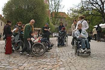 Skupina handicapovaných návštvěníků s asistenty na I. nádvoří zámku Český Krumlov, foto: Lubor Mrázek 
