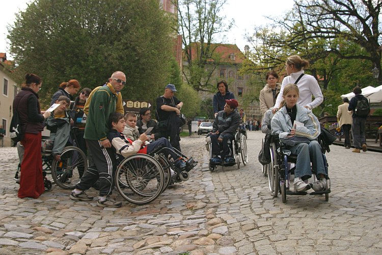 Skupina handicapovaných návštvěníků s asistenty na I. nádvoří zámku Český Krumlov, foto: Lubor Mrázek