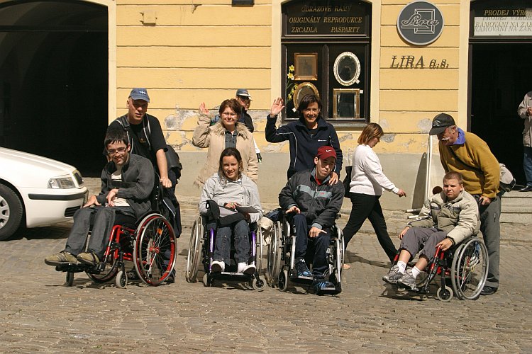 Skupina handicapovaných návštvěníků s asistenty v historickém centru města Český Krumlov, foto: Lubor Mrázek